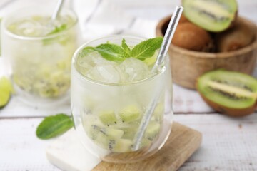 Refreshing drink with kiwi and mint on white table, closeup