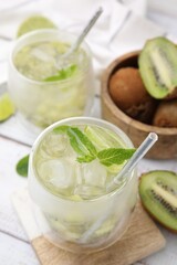 Refreshing drink with kiwi and mint on white table, closeup