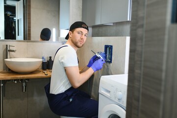 Plumber installing toilet bowl in restroom, work in bathroom.