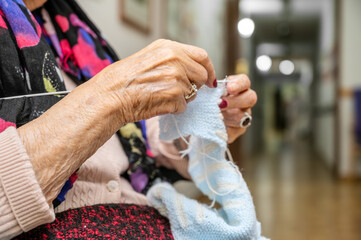 Elderly woman crocheting in a handicraft course as a hobby or occupational therapy at nursing home. High quality photo