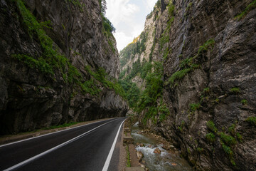 Amazing curved road between the mountains. Wide angle landscape photo with the road from Bicaz Gorges (Cheile Bicazului in Romanian language) landmark in Transylvania and Moldova.