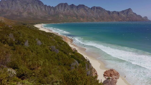 South Africa aerial drone Garden Route Koeel Bay Dappat Se Gat cinematic windy grass surf waves crashing Kogel Bay Beach Cape Town coastline aqua deep blue water Gordon's Bay forward pan up movement