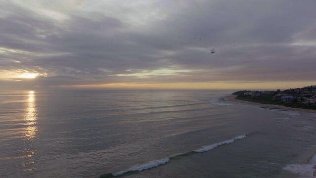 South Africa drone aerial Jeffreys Bay surf town stunning early morning sunrise golden sun on ocean surfer wave groundswell Sunrise sunset drone JBay stunning coastline beach cinematic backward motion