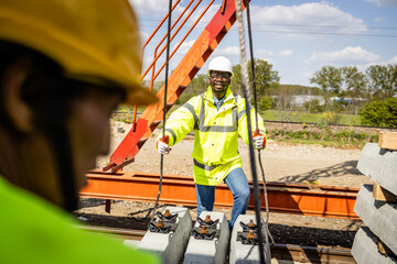 Railroad construction. Workers placing railroad ties and building new fast railway.