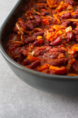Healthy breakfasts and lunches, stewed red beans with carrots, onions and tomatoes, top view of an oval ceramic roaster with stewed legumes