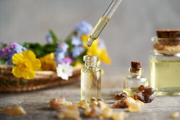 Essential oil bottle with a glass dropper and spring flowers