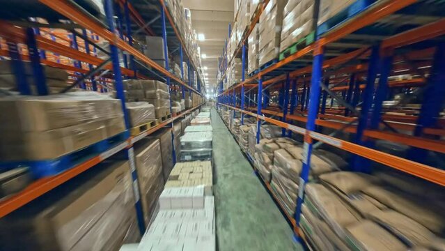 FPV Flight Between The Racks With Boxes Inside The Merchandise Warehouse. - aerial