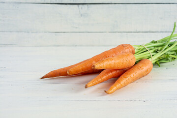 Fresh orange carrot on white wooden background