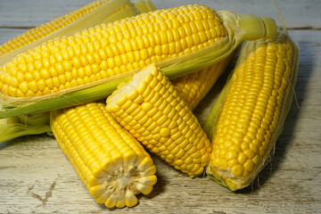 Fresh corn cobs on wooden table