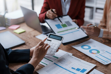 Group of business people working together on new project with planning analytical report at meeting. Businesspeople meeting together pointing to graph assess business profits.