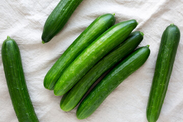 Organic Mini Baby Cucumbers on a white wooden background, top view. Flat lay, overhead, from above.
