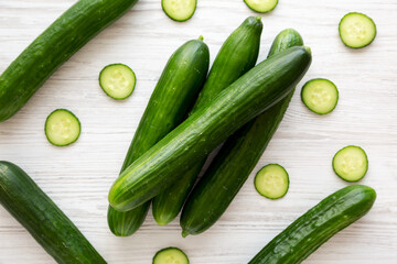 Organic Mini Baby Cucumbers on a white wooden background, top view. Flat lay, overhead, from above.