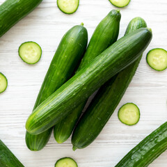 Organic Mini Baby Cucumbers on a white wooden background, top view. Flat lay, overhead, from above.