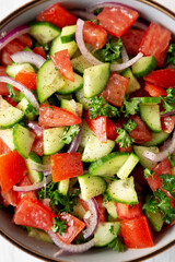 Homemade Mediterranean Cucumber Tomato Salad in a Bowl, top view. Flat lay, overhead, from above. Closeup.
