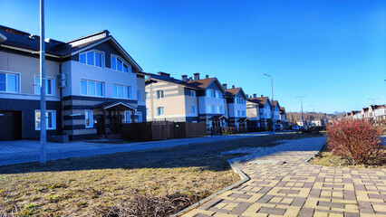 New house on the street in small village or town in a spring or atutumn day. Landscape with...