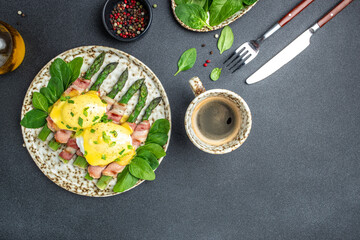 Delicious breakfast with eggs Benedict and green asparagus wrapped in grilled bacon and a cup of coffee. banner, menu, recipe place for text, top view
