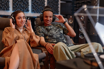 Portrait of young couple listening to vinyl records at home and enjoying sound quality