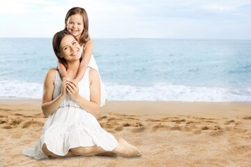 Fototapeta na wymiar Smiling mother and daughter having fun on sea background