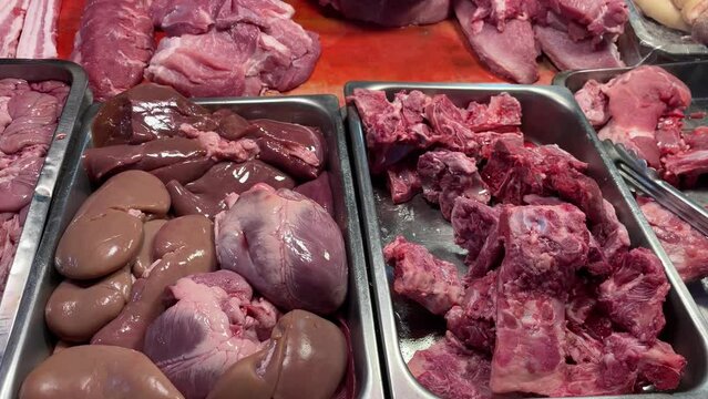 Raw pork meat slice, liver and bones on kiosk for sale at fresh market, Thailand