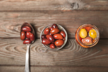 Pickled olives in glass jar. On a wooden background.Tasty olives on wooden table.Close-up.Place for text.Copy space. Delicious healthy mediterranean food.Vegan