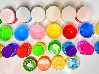 a toy for children mucus and liquid - multiple colour of slime bottle on table 