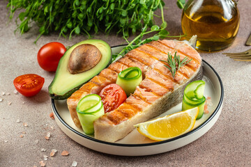 Dish grilled salmon steak with avocado and fresh vegetable salad. Keto diet concept healthy food, Healthy fats, clean eating for weight loss. top view