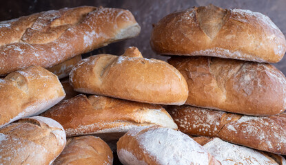 Freshly baked bread. Sourdough loaf with crispy crust on bakery retail store. Food concept. Homemade fresh rustic loaves. Assortment of traditional bakery goods. Tasty and delicious. Healthy eating.