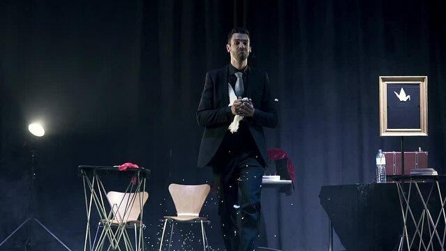 Magician making a dove appear in a magic trick. Slow motion shot.