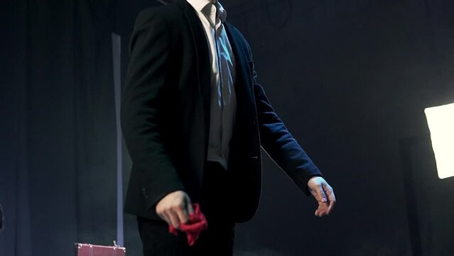 Magician doing a magic show in front of the public with a red scarf