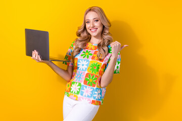 Photo of sweet shiny woman dressed flower print t-shirt working modern device thumb empty space isolated yellow color background
