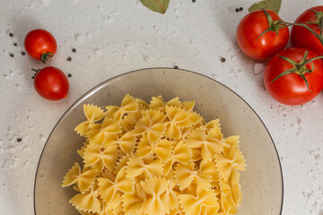 Italian pasta on table with tomatoes, pepper and different species