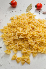 Italian pasta on table with tomatoes, pepper and different species