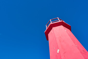 Red lighthouse isolated in blue sky