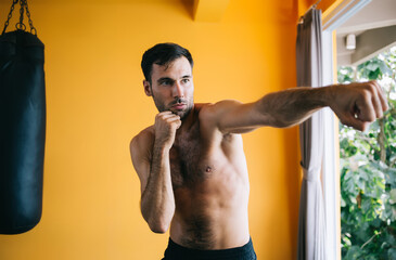 Strong man practicing punches in gym