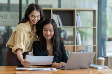 Two Asian business women Discussing new startup projects Financial reports, project presentations, analytical concepts, planning and financial statistics and investment markets at the office.