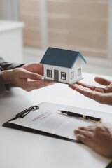 Real estate agents explain models of housing estates in projects to elaborate to clients, explaining and presenting information about homes and purchasing loans. Real estate trading concept.