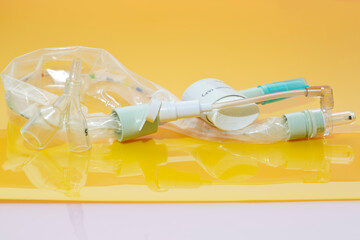 Closed suction system for intubated, ventilated neonates and pediatric patients with protective sleeve to isolate pathogens inside and avoid cross-infection on yellow background