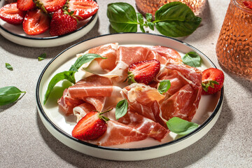 Prosciutto di parma or jamon serrano with strawberries. antipasto. Food recipe background. Close up