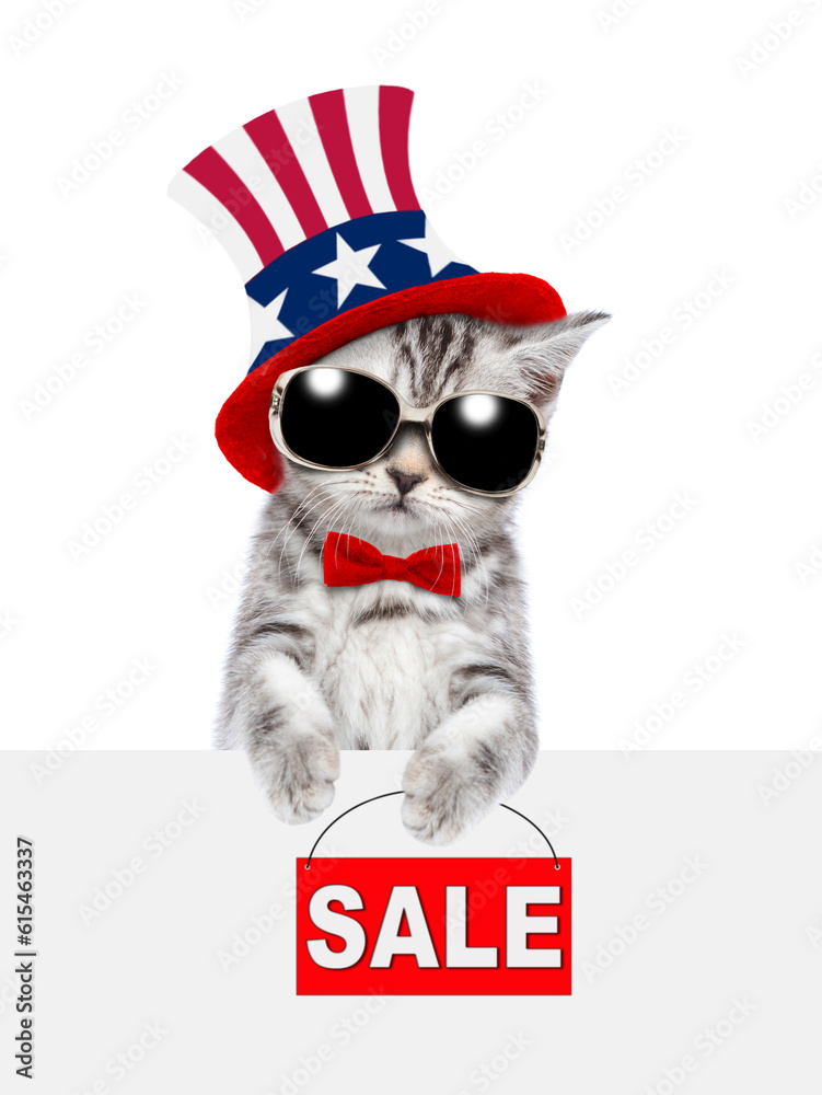 Poster cute kitten wearing like uncle sam looks from behinde empty white banner and shows signboard with la