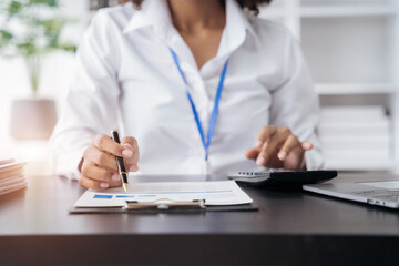 Business women are calculating income-expenditure and analyzing real estate investment data at office, Accounting Financial and tax systems concept.