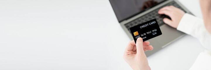 Hands holding credit card and using laptop. Online shopping. Banner