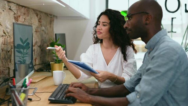 Video of smart business people working together with laptop while talking in the coworking place.
