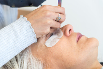 latina woman performing beauty treatments to adult woman, aesthetic center, cosmetics skin care treatment concept.