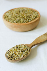 Raw freekeh or firik in wooden spoon and bowl on white background. Concept of healthy eating. Rustic style. Vertical orientation. Selective focus