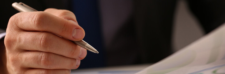 Businessman pen pointing at business document for chart and graph data analysis. Business financial and accounting concept