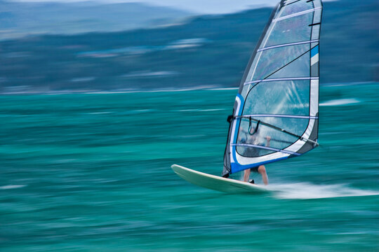 Windsurfer zooms across the water at Pigeon Point in Tobago; Tobago, Republic of Trinidad and Tobago