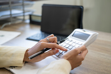 Business woman accountant or banker making calculations. Savings,Business Financing Accounting Banking and economy Concept. Image of hands using calculator on desk about cost at office.