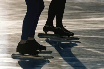 Legs and feet of speed skaters on a frozen lake; Lake Placid, New York, United States of America