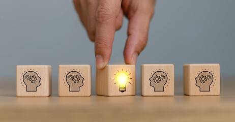 Hand choose cube wooden block stack with lightbulb on human icon stack for idea and leadership and...