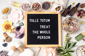 Letter board with text Tolle totum meaning treat the whole person in latin. Naturopatical...